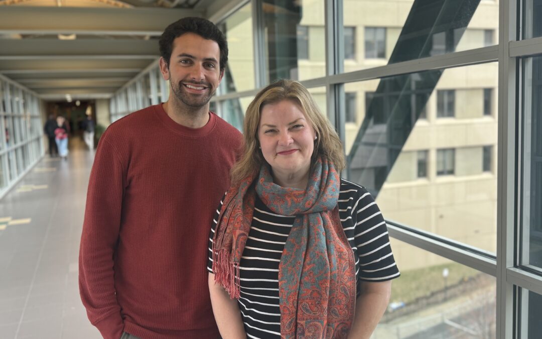 Two people standing by a window: Ashton Larking & Rachel Burcin